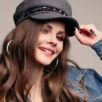 Fashionable pretty brunette girl in stylish hat and denim jacket