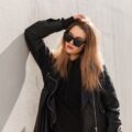 Beautiful urban fashion woman with glasses in black leather jacket in the city Beautiful urban fashion woman with glasses in black leather jacket in the city