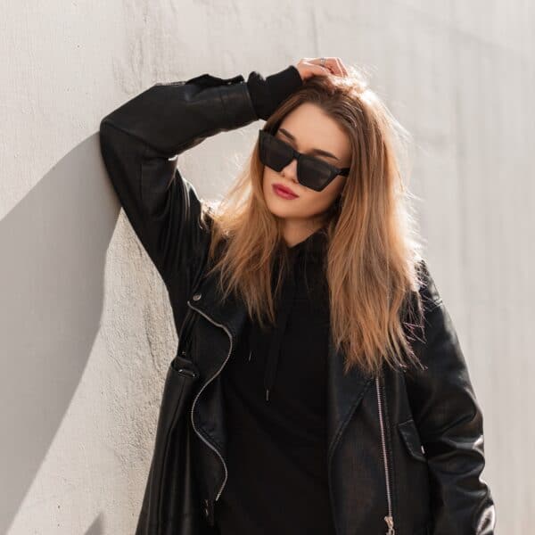 Beautiful urban fashion woman with glasses in black leather jacket in the city Beautiful urban fashion woman with glasses in black leather jacket in the city
